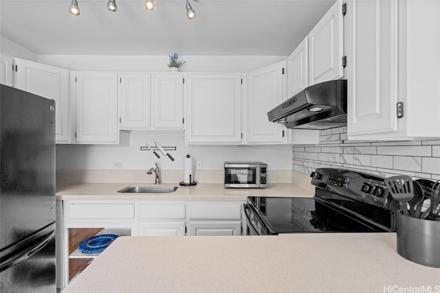 kitchen featuring black / electric stove, fridge, sink, and white cabinets