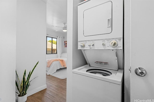 clothes washing area with stacked washing maching and dryer and hardwood / wood-style floors