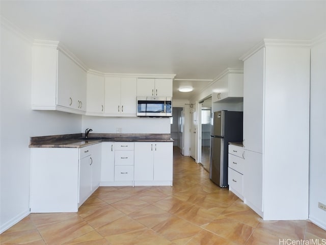 kitchen with white cabinetry, sink, and stainless steel appliances