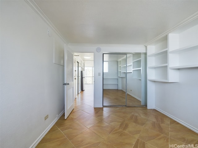 unfurnished bedroom with crown molding, a closet, stainless steel refrigerator, and light tile patterned flooring