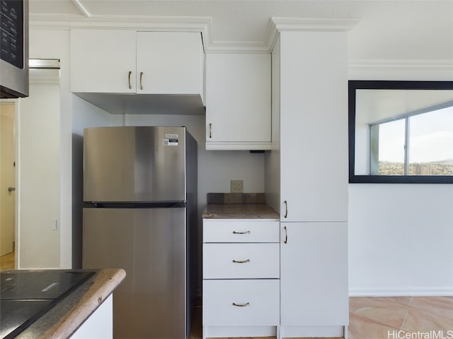 kitchen with ornamental molding, stainless steel appliances, white cabinets, and light tile patterned flooring