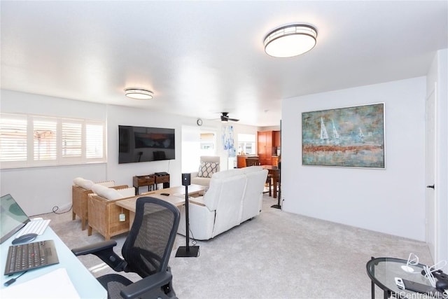 carpeted home office featuring ceiling fan