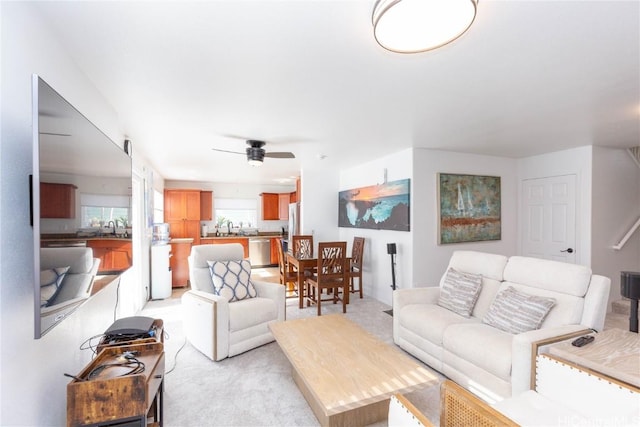 living room featuring sink, light carpet, and ceiling fan