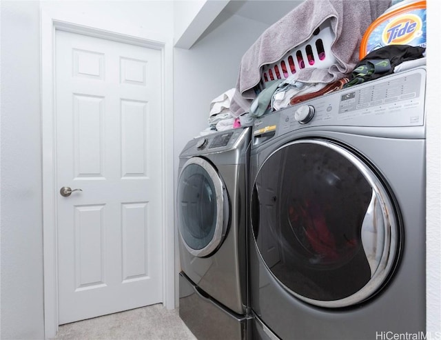 clothes washing area with washer and clothes dryer