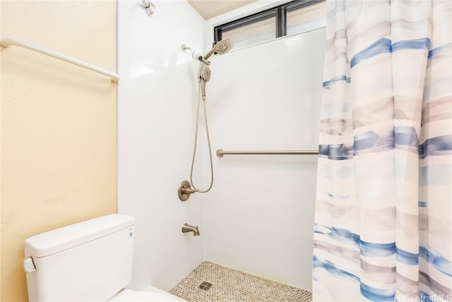 bathroom with a shower with shower curtain and toilet