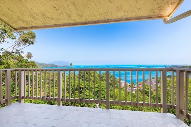 balcony featuring a beach view and a water view