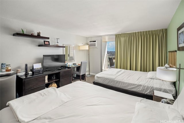 bedroom featuring a wall mounted air conditioner, carpet floors, and fridge