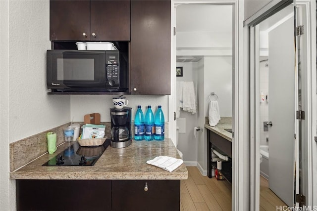 kitchen featuring dark brown cabinetry and light wood-type flooring