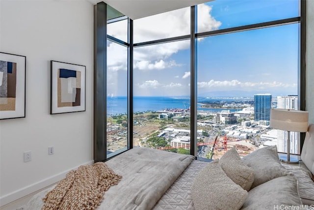 bedroom with floor to ceiling windows and a water view