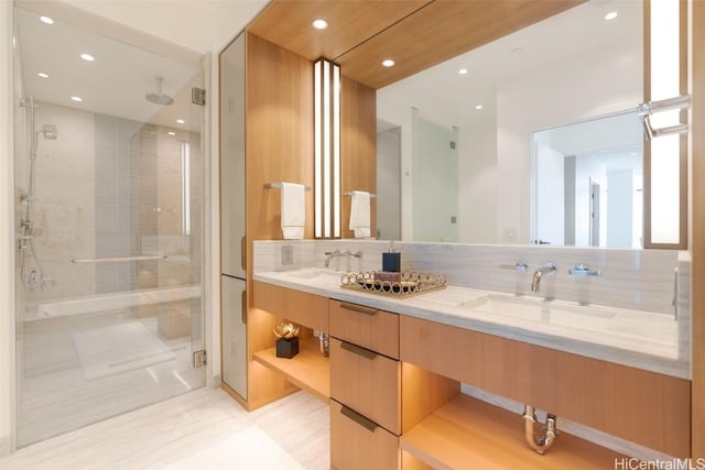 bathroom featuring a shower with door, vanity, and backsplash