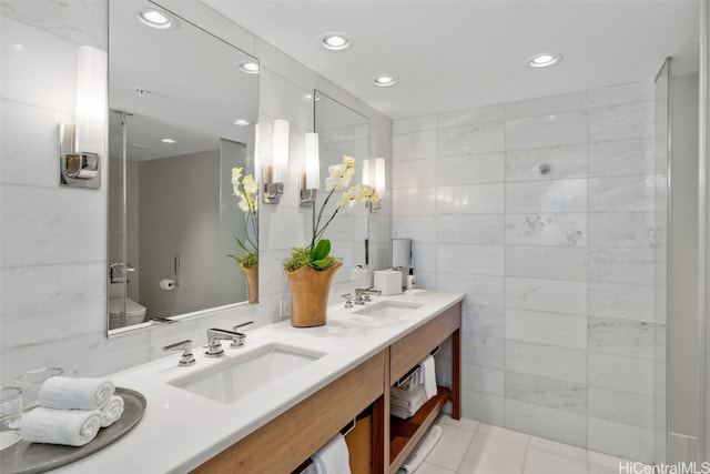 bathroom with vanity, tile walls, tile patterned floors, and toilet