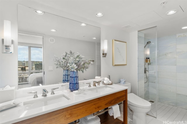 bathroom with vanity, toilet, and a shower with door