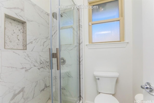 bathroom with a shower with door and toilet