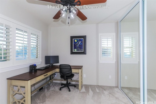 carpeted office space featuring ceiling fan