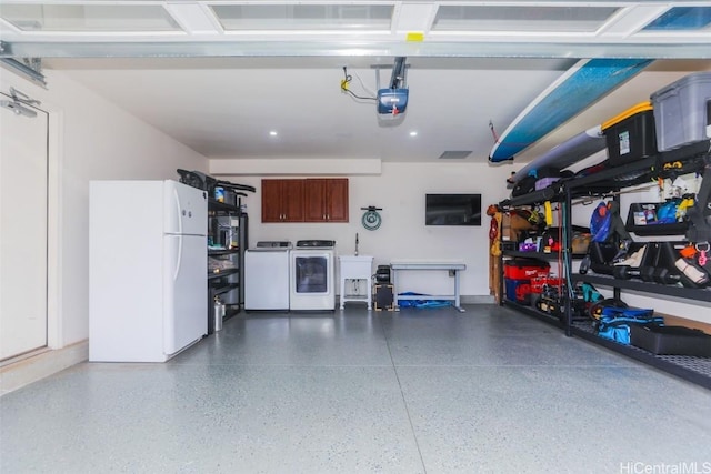 garage with a garage door opener, washer and dryer, and white refrigerator