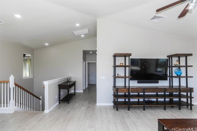 living room with hardwood / wood-style floors, vaulted ceiling, and ceiling fan