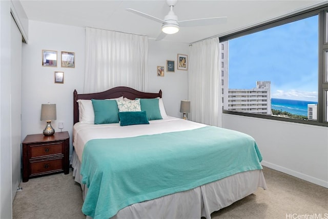 carpeted bedroom featuring ceiling fan and a closet