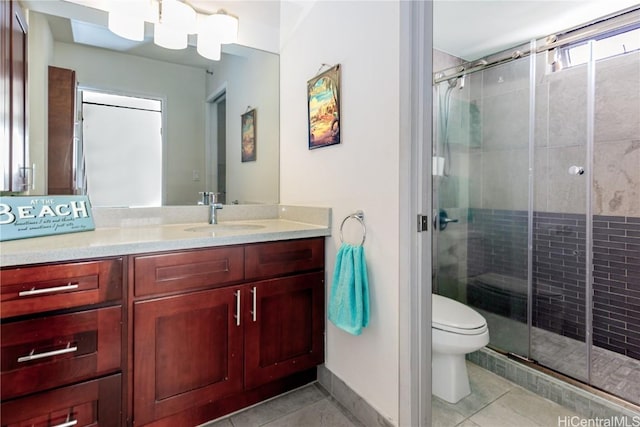 bathroom featuring tile patterned flooring, vanity, a shower with door, and toilet