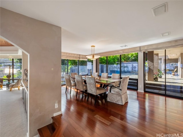 dining room with dark hardwood / wood-style flooring and a wall of windows