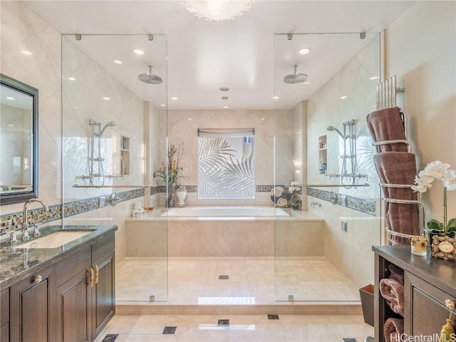 bathroom with vanity, tile patterned floors, tile walls, and separate shower and tub