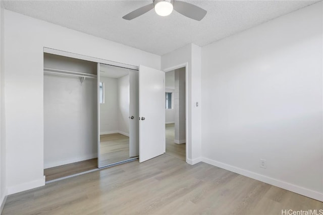 unfurnished bedroom featuring a textured ceiling, a closet, ceiling fan, and light wood-type flooring