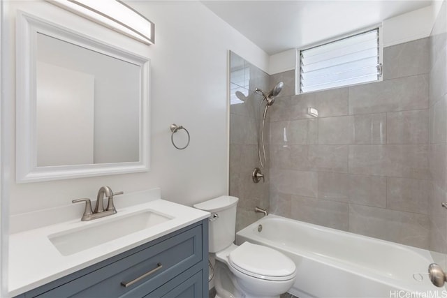 full bathroom featuring vanity, tiled shower / bath combo, and toilet