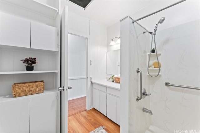 bathroom with a shower, wood finished floors, and vanity