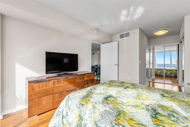 bedroom with access to exterior and light hardwood / wood-style flooring