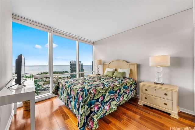 bedroom featuring a wall of windows and dark hardwood / wood-style floors