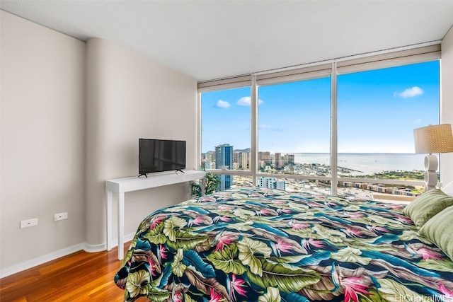 bedroom featuring hardwood / wood-style flooring and a wall of windows