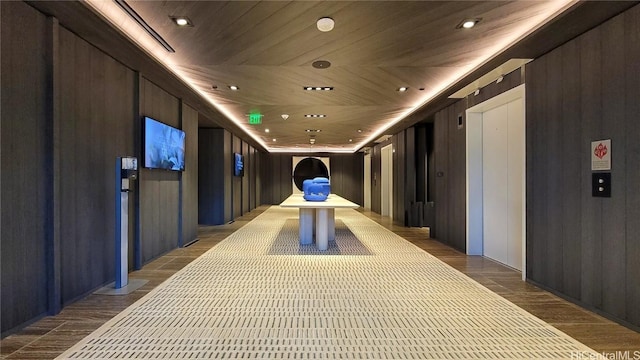 interior space featuring wood ceiling and wood walls