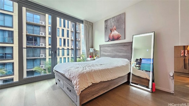 bedroom with hardwood / wood-style flooring and a wall of windows