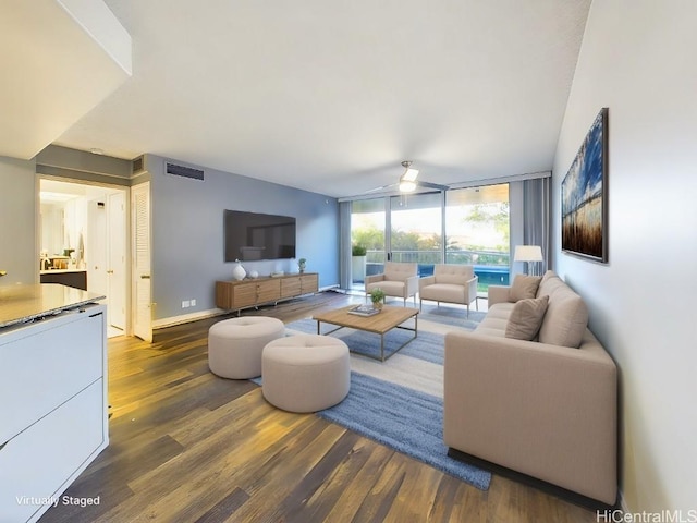 living room with ceiling fan, a wall of windows, and dark hardwood / wood-style flooring