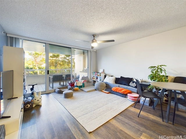 living room featuring ceiling fan, dark wood-type flooring, floor to ceiling windows, and a textured ceiling