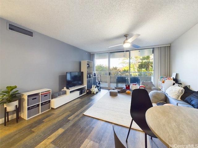 living room with ceiling fan, dark wood-type flooring, floor to ceiling windows, and a textured ceiling