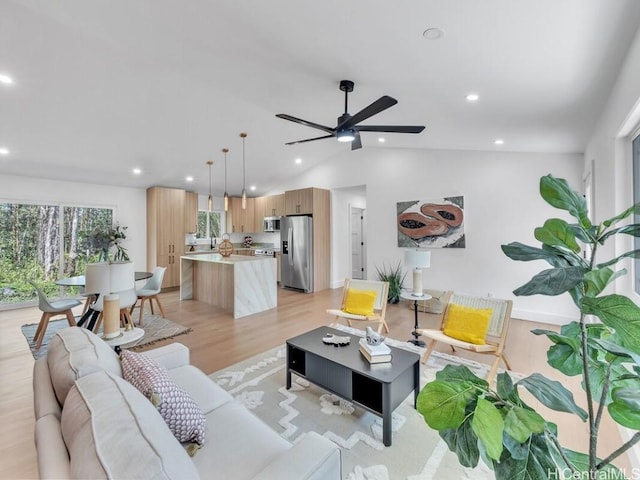 living room with lofted ceiling, ceiling fan, and light wood-type flooring