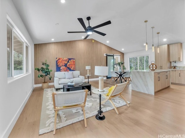 living room with lofted ceiling, light hardwood / wood-style flooring, and ceiling fan