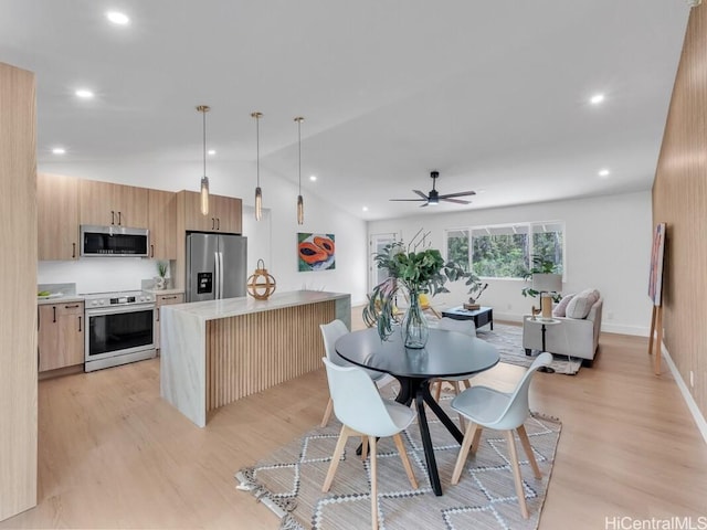 kitchen featuring a center island, light hardwood / wood-style flooring, pendant lighting, ceiling fan, and stainless steel appliances