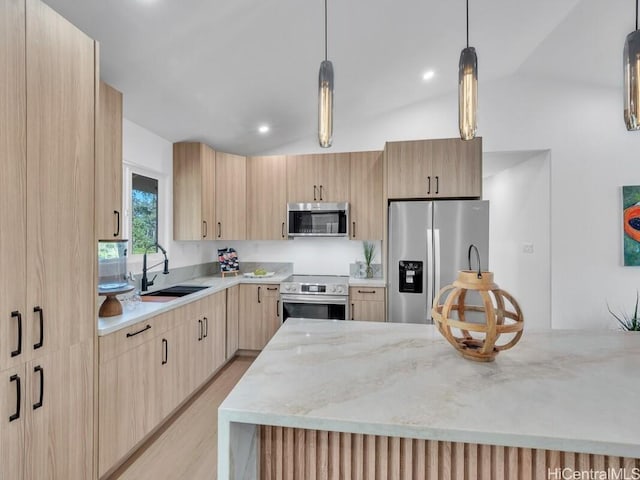 kitchen featuring stainless steel appliances, pendant lighting, light brown cabinets, and light stone counters