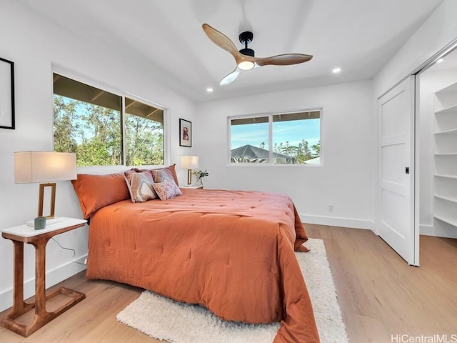 bedroom with a closet, ceiling fan, and light wood-type flooring