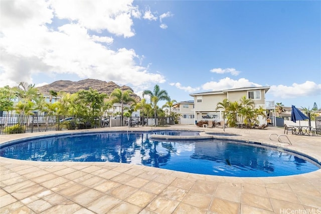 view of pool featuring an in ground hot tub, a mountain view, and a patio