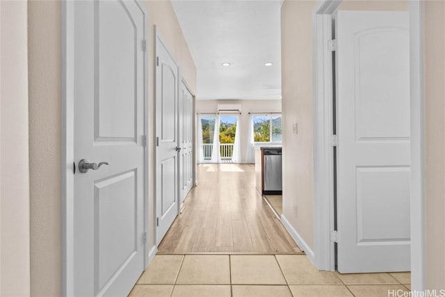 hall featuring light tile patterned floors and a wall mounted AC