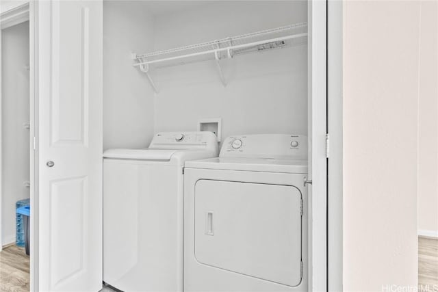 laundry area featuring independent washer and dryer and light hardwood / wood-style flooring