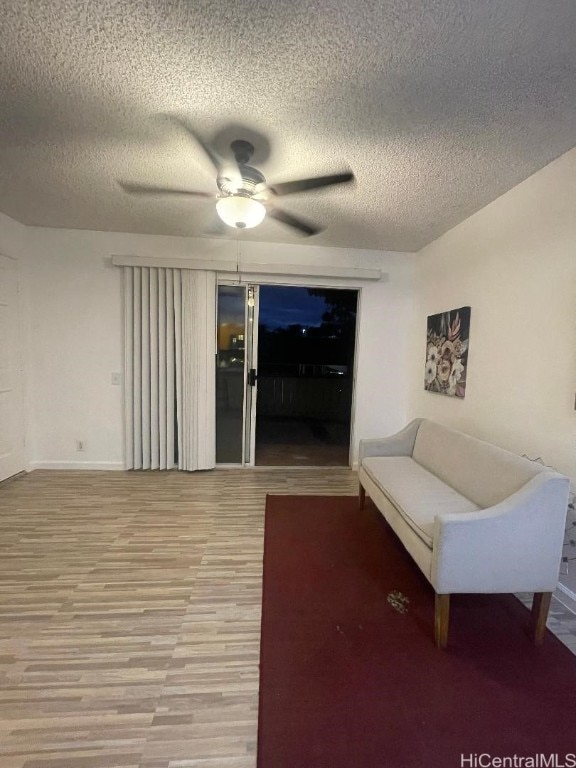 unfurnished living room with ceiling fan, wood-type flooring, and a textured ceiling