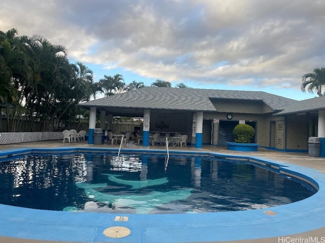 view of pool with a bar and a patio