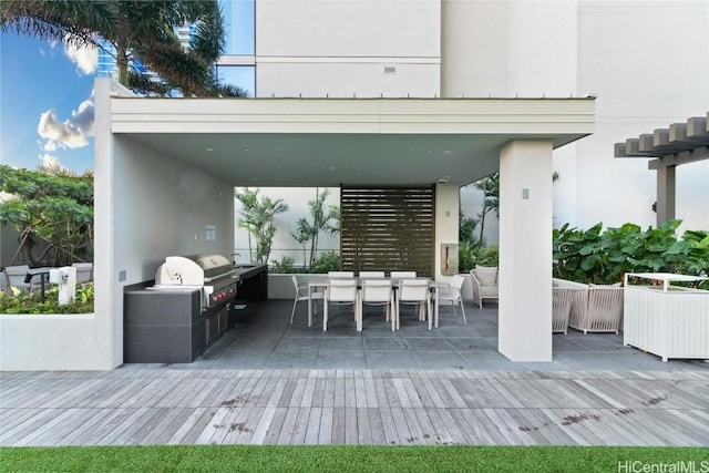 view of patio / terrace featuring outdoor dining space, exterior kitchen, and area for grilling