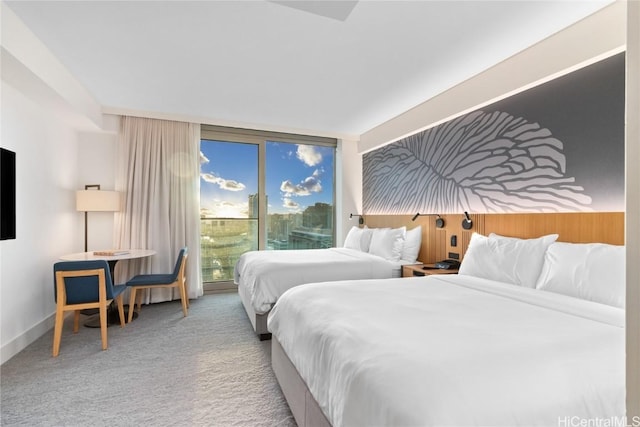 bedroom with baseboards, a wall of windows, carpet flooring, and access to exterior