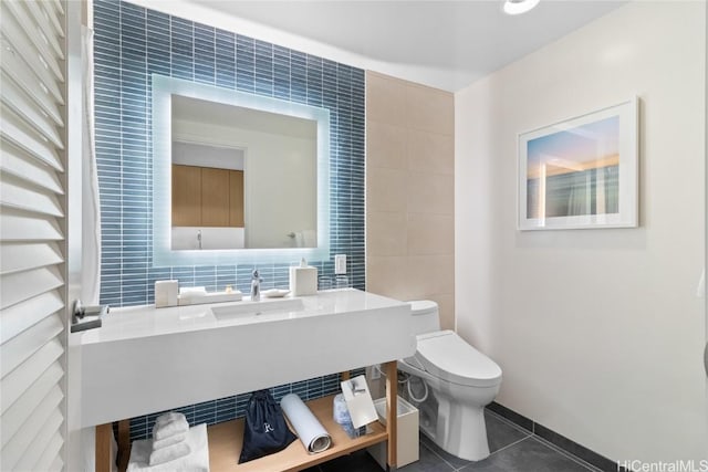 half bath featuring toilet, tile walls, and tile patterned floors