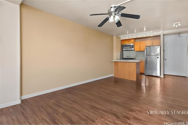 kitchen with stainless steel appliances, dark wood-type flooring, backsplash, and ceiling fan