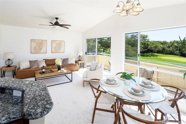 living room featuring carpet, vaulted ceiling, and ceiling fan with notable chandelier